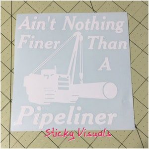 May include: White vinyl decal with the text "Ain't Nothing Finer Than A  Pipeliner" and a silhouette of a crane lifting a pipe. The decal also includes the text "Sticky Visuals".