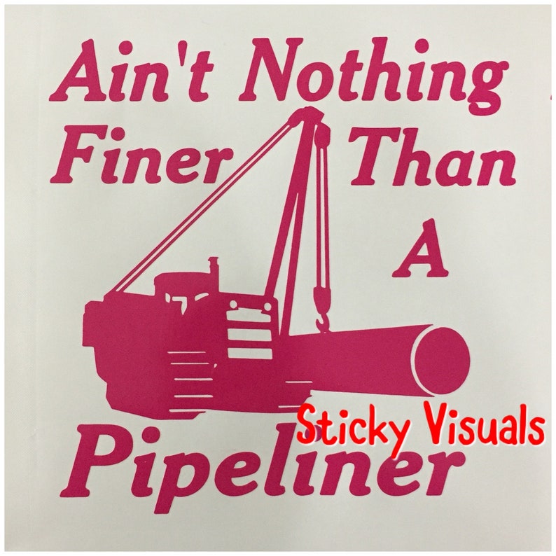 May include: Pink silhouette of a construction vehicle with a crane lifting a pipe. The text "Ain't Nothing Finer Than A Pipeliner" is written above the vehicle. The text "Sticky Visuals" is written below the vehicle.