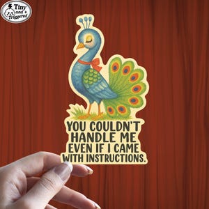May include: A sticker featuring a cartoon peacock with blue and green feathers, a red bow, and the text "YOU COULDN'T HANDLE ME EVEN IF I CAME WITH INSTRUCTIONS." The sticker has a vintage, whimsical style.