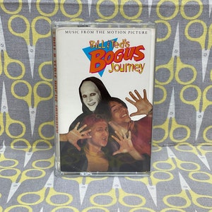 Op de afbeelding: Een cassettebandje met een kleurrijk beeld van Bill & Ted's Bogus Journey. De tekst "Music from the Motion Picture" staat bovenaan de cassette.