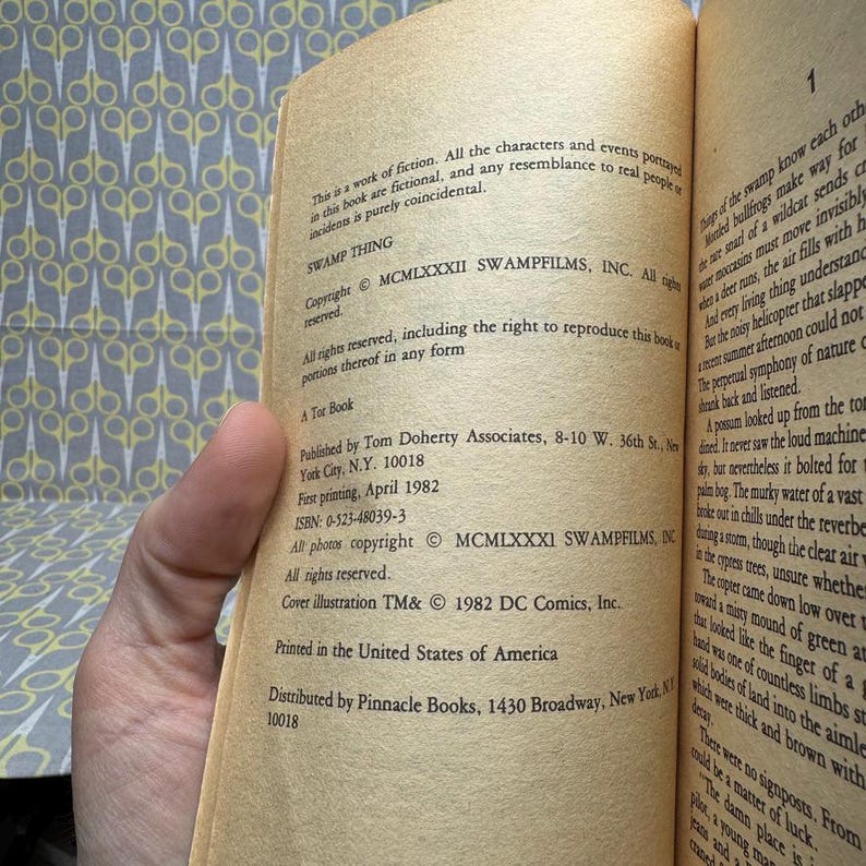 May include: Open book with text from the comic book "Swamp Thing". The text includes the copyright information, publisher details, and the phrase "Printed in the United States of America". The pages are yellowed with age.