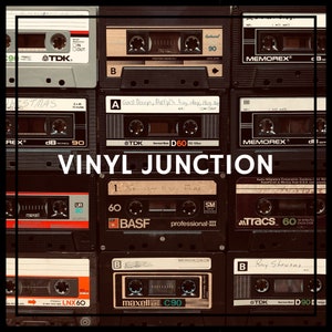 May include: A collection of vintage audio cassette tapes with various labels, including TDK, Memorex, and BASF. The tapes are arranged in a grid pattern and feature different colors and designs. The text "VINYL JUNCTION" is displayed in the center of the image.