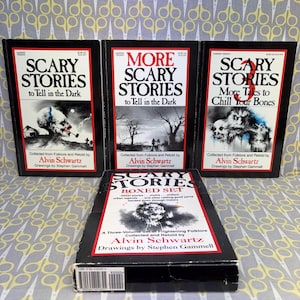 May include: A three-volume paperback book set titled Scary Stories to Tell in the Dark, More Scary Stories to Tell in the Dark, and Scary Stories 3: More Tales to Chill Your Bones by Alvin Schwartz, featuring illustrations by Stephen Gammell.