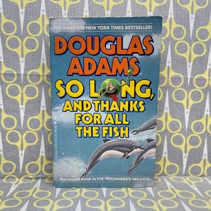 Könnte beinhalten: Ein Taschenbuchcover mit einem grünen, cartoonartigen Außerirdischen, der die Zunge herausstreckt. Der Buchtitel lautet "So Long, and Thanks for All the Fish" von Douglas Adams. Das Buch ist das vierte der Hitchhiker's Trilogy.