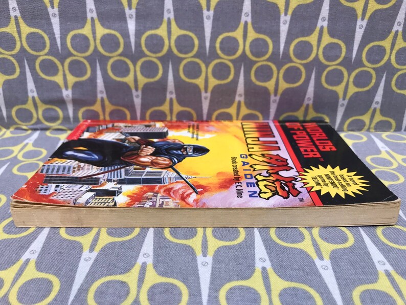 May include: A paperback book titled "Worlds of Power: Ninja Gaiden" with a black and red cover featuring a ninja character in a fighting pose. The book is based on the video game.