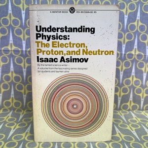 Könnte beinhalten: Ein Vintage-Paperback-Buchcover mit weißem Hintergrund und einem farbenfrohen Design aus konzentrischen Kreisen. Der Titel lautet "Physik verstehen: Das Elektron, das Proton und das Neutron" von Isaac Asimov.
