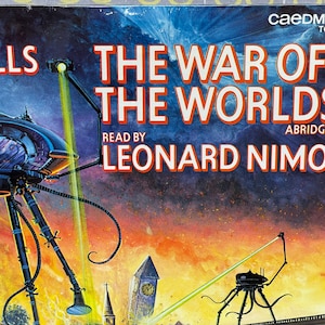 May include: A vintage audio cassette tape cover featuring an illustration of a Martian tripod from the book "The War of the Worlds" by H.G. Wells. The cover is blue and orange with the title "The War of the Worlds" in white text. The text "Read by Leonard Nimoy" and "Abridged" are also visible on the cover.