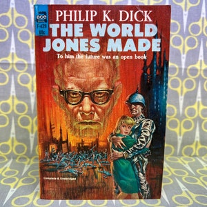 May include: A vintage paperback book cover with a red background featuring a man with glasses and a white beard. The title is "The World Jones Made" by Philip K. Dick. The tagline reads "To him the future was an open book".