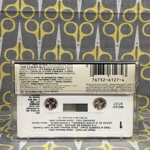 May include: A white cassette tape with a clear plastic case. The tape is labeled "Twist of Fate" by Olivia Newton-John. The track list includes "Take a Chance", "It's Gonna Be Special", "Catch 22", "Shaking You", and "Livin' in Desperate Times".