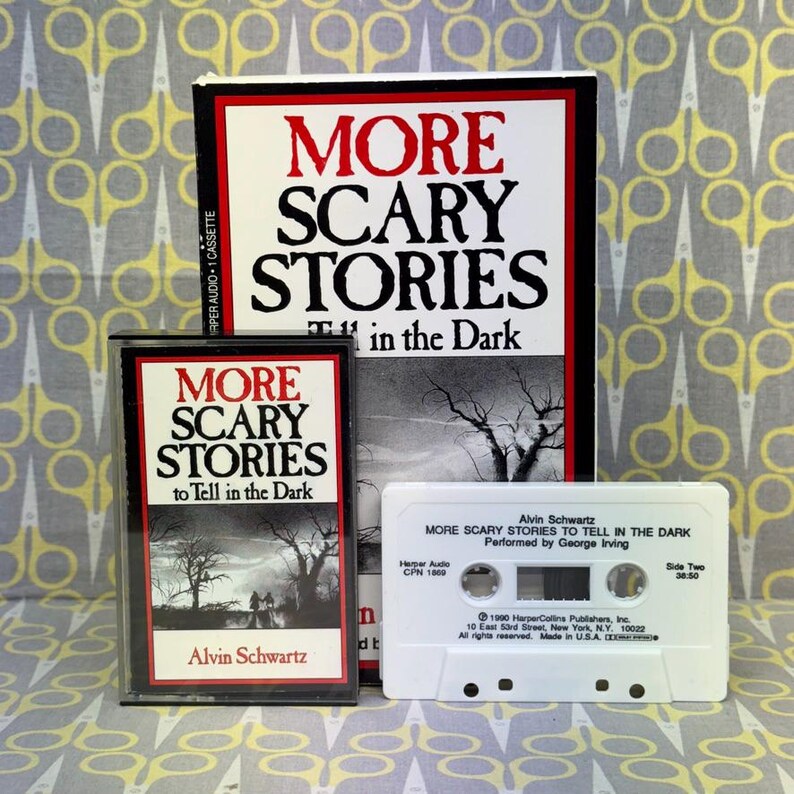 Puede incluir: Una colecci&oacute;n de art&iacute;culos vintage con el libro y la cinta de casete de "More Scary Stories to Tell in the Dark" de Alvin Schwartz. La portada del libro y las etiquetas del casete tienen el t&iacute;tulo en rojo y negro. El casete es blanco.