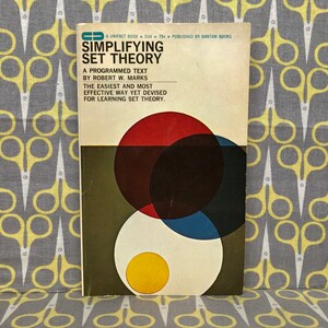 May include: A vintage book cover with a green, red, blue, and yellow geometric design. The title is "Simplifying Set Theory" by Robert W. Marks. The book is a programmed text and describes itself as the easiest and most effective way to learn set theory.