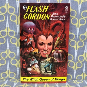 Op de afbeelding: Een vintage paperback boekomslag met Flash Gordon, een stripfiguur, met de titel "The Witch Queen of Mongo". De omslagillustratie toont een vrouw met rood haar en een kroon, omringd door monsterlijke wezens.