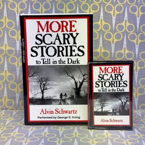Puede incluir: Un conjunto de libro y casete titulado "More Scary Stories to Tell in the Dark" de Alvin Schwartz. El libro y el casete presentan una ilustraci&oacute;n en blanco y negro de una escena de bosque espeluznante. El libro est&aacute; en una caja negra con texto rojo y blanco.