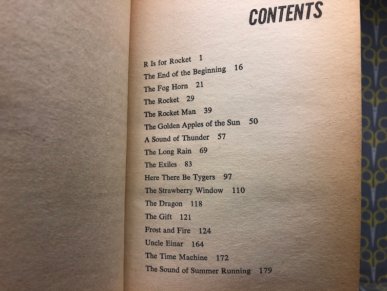 May include: A book with a table of contents listing the chapters and page numbers. The chapters include "R Is for Rocket", "The End of the Beginning", "The Fog Horn", "The Rocket", "The Rocket Man", "The Golden Apples of the Sun", "A Sound of Thunder", "The Long Rain", "The Exiles", "Here There Be Tygers", "The Strawberry Window", "The Dragon", "The Gift", "Frost and Fire", "Uncle Einar", "The Time Machine", and "The Sound of Summer Running".