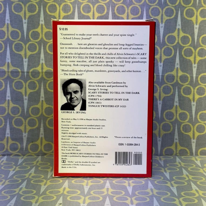 Puede incluir: Una funda de casete de audio vintage para "More Scary Stories to Tell in the Dark". La funda roja y blanca presenta texto y un retrato de George S. Irving. La parte posterior de la funda incluye una rese&ntilde;a y un ISBN.