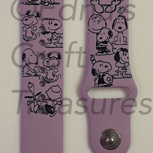 Puede incluir: Una banda de reloj Apple de silicona morada con un estampado en blanco y negro de Snoopy y Woodstock. La banda tiene una hebilla plateada.
