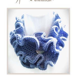 May include: A blue and white crocheted scarflette with a ruffled edge and a button closure. The scarf is displayed on a white background. The text "Comber Ebbtide Scarflette" is below the scarf. The logo for Wools & Tools is at the top.
