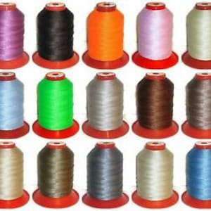 May include: Assortment of 15 spools of waxed thread in various colors, including purple, black, orange, pink, light blue, green, white, brown, beige, gray, and blue. The spools are all the same size and have red plastic bobbins.
