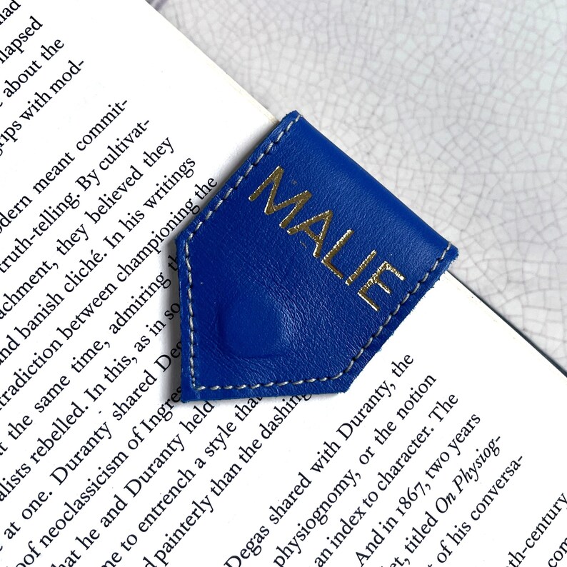 May include: A blue leather bookmark with a gold inscription that reads "MALIE".