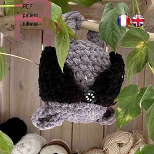 May include: A handmade crochet spider toy with a black body and white cross detail, displayed with gray and black crocheted plush toy, yarn balls, and the text "PDF pattern tutoriel".