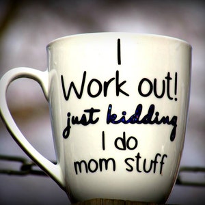 May include: White ceramic coffee mug with black lettering that reads "I work out! Just kidding I do mom stuff".
