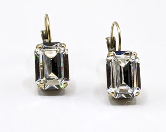 May include: A pair of gold-tone earrings with clear emerald-cut crystal stones.