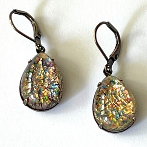 May include: A pair of silver teardrop earrings with iridescent opal-like stones.