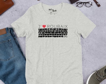 May include: A grey t-shirt with a black and white graphic of a brick wall with a red heart and the text "J' ROUBAIX" and a bicycle.
