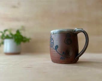 Handmade ceramic 12 ounce mug, red surface with blue flowers