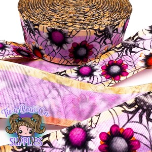 Puede incluir: Cinta decorativa con temática de Halloween. La cinta tiene un fondo morado y blanco con telarañas, arañas y flores rosas y naranjas. Ideal para manualidades y envolver regalos.