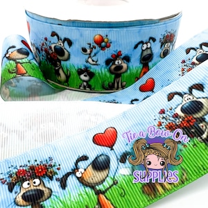 May include: A roll of blue ribbon with a repeating pattern of cartoon dogs. The dogs are in various poses, some holding flowers or balloons. The ribbon has a striped background and a green border.