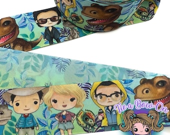 May include: Green and blue ribbon with a repeating pattern of cartoon characters and dinosaurs. The characters are wearing casual clothing and have a cartoon style. The text "Tie a Bow On" is visible in the image.