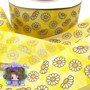 May include: Yellow grosgrain ribbon with a white daisy print. The ribbon has a subtle watercolor effect.
