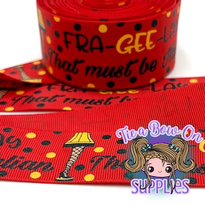 Puede incluir: Cinta roja con lunares negros y amarillos y texto que dice "FRA-GEE-LAY" y "That must be it". La cinta también presenta una ilustración de una lámpara de pierna. La cinta es de Tie a Bow On Supplies.