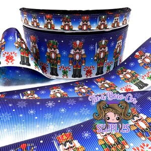 Nussknacker auf Schneeflocken-Hintergrund, doppelseitiges USDR-Ripsband | 3/8" oder 1,5" einseitiges Designer-Ripsband