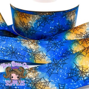 May include: Blue and yellow ribbon with a spiderweb design. The ribbon has a watercolor effect with a blue background and yellow accents. Black spiderwebs are printed across the ribbon. The text "Tie a Bow On SUPPLIES" is visible.