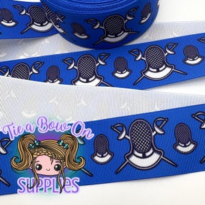 May include: Blue ribbon with a repeating pattern of fencing masks and swords in white and black. The ribbon is layered over a white ribbon with a subtle striped pattern. The image also includes a logo with the text "Tie a Bow On SUPPLIES".