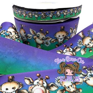 Puede incluir: Un carrete de cinta de grosgrain con degradado morado y verde que presenta un patrón repetitivo de jirafas de dibujos animados con margaritas blancas. La cinta tiene una superficie acanalada y un logo de marca de agua Tie a Bow on Supplies.