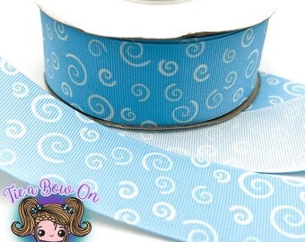 May include: A spool of light blue ribbon with a white swirl pattern. The ribbon is 1.5 inches wide and is perfect for crafting and decorating.