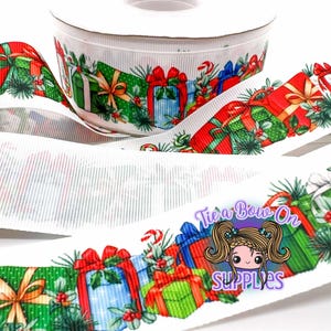 Könnte beinhalten: Weiße Bandrolle mit einem sich wiederholenden Muster aus bunten Geschenkverpackungen, Stechpalmen und Zuckerstangen. Das Band zeigt rote, grüne, blaue und goldene Geschenkboxen mit roten Schleifen. Der Text "Tie a Bow On Supplies" ist sichtbar.
