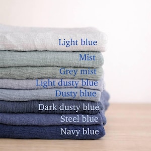 A stack of various colored towels, each labeled with a different color, arranged in a visually appealing manner.