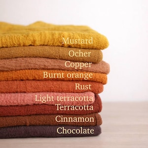 A stack of colorful towels in various shades of yellow, orange, brown, and red, with labels for each color.