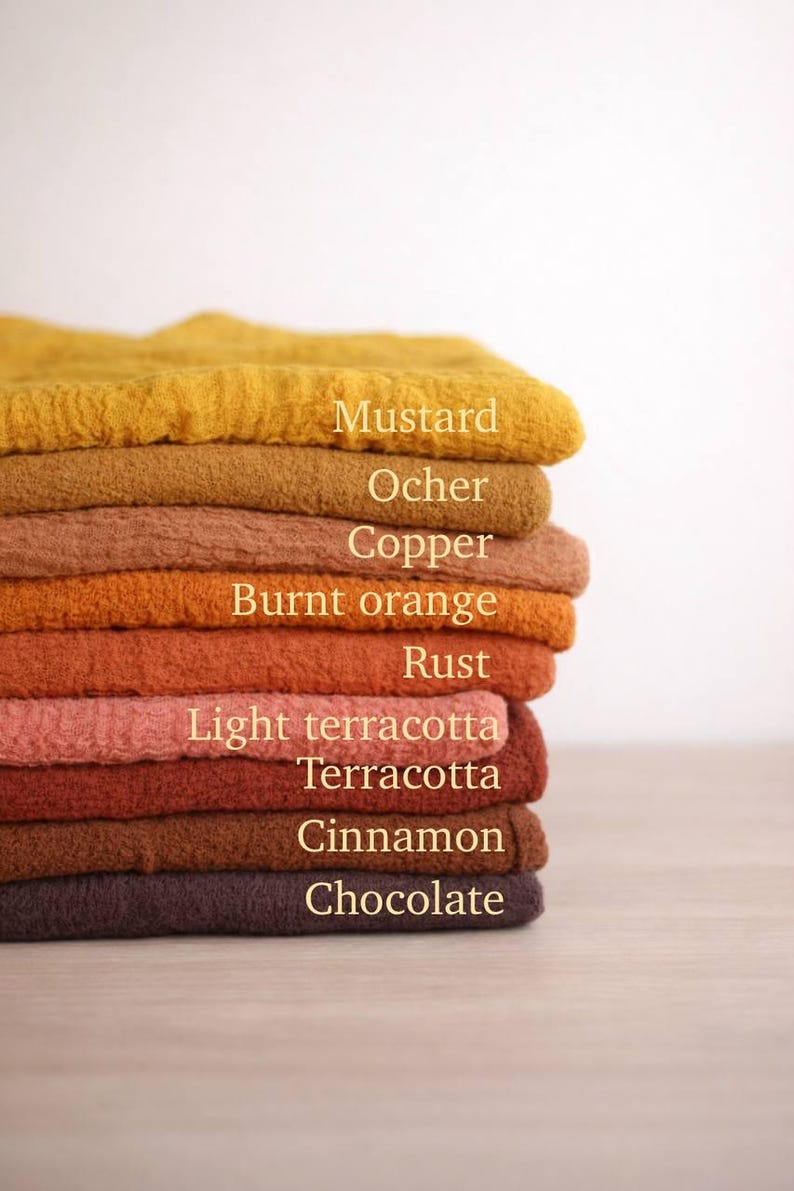 A stack of colorful towels in various shades of yellow, orange, brown, and red, with labels for each color.
