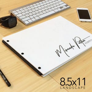 May include: White portfolio with black binding and black dots. The portfolio is 8.5x11 inches and has the name "Miranda Patton" written in black cursive on the front. The text "Portfolio" is also written in black on the front.