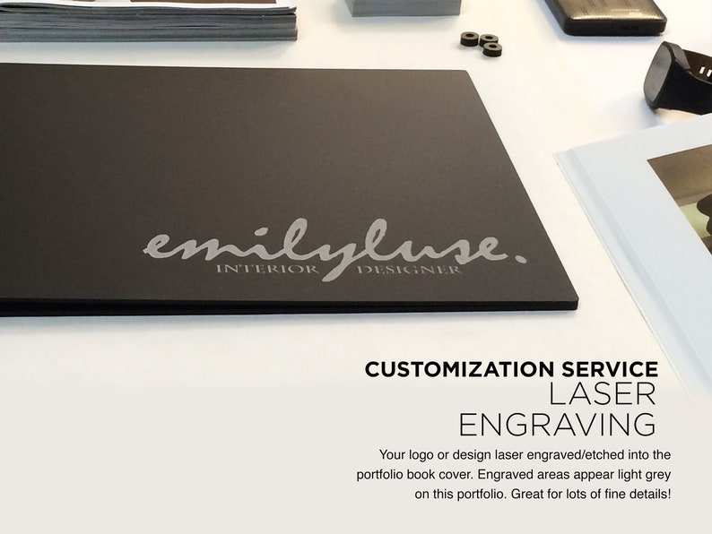 K&ouml;nnte beinhalten: Ein schwarzes Portfolio mit dem Text "emilyluse. INTERIOR DESIGNER" in Silber graviert. Der Text "CUSTOMIZATION SERVICE LASER ENGRAVING" ist in Wei&szlig; unter dem Portfolio gedruckt. Der Text "Your logo or design laser engraved/etched into the portfolio book cover. Engraved areas appear light grey on this portfolio. Great for lots of fine details!" ist in Schwarz unter dem Text "LASER ENGRAVING" gedruckt.