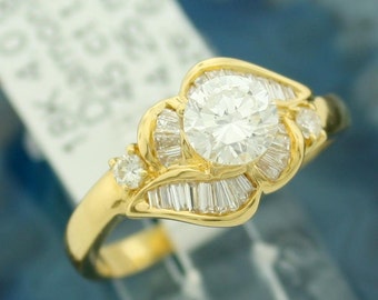 May include: A gold ring with a large round diamond surrounded by smaller baguette diamonds.