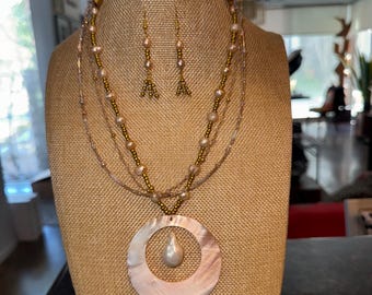 Conjunto de colar e brincos em tons de rosa, pérola e dourado