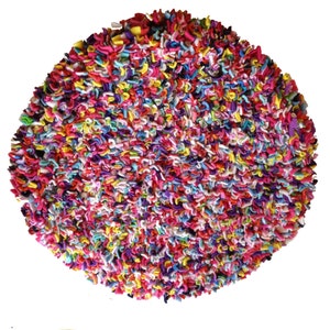 May include: A circular rug with a dense, textured surface. The rug is made of tightly packed, looped fabric in a variety of bright colours, including pink, red, yellow, blue, and green. The rug's diameter is approximately 91 cm.