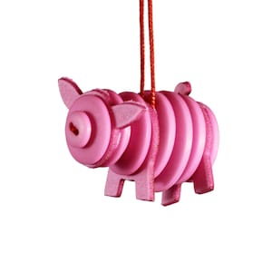 May include: A pink pig ornament made of stacked circles, hanging from a red string.