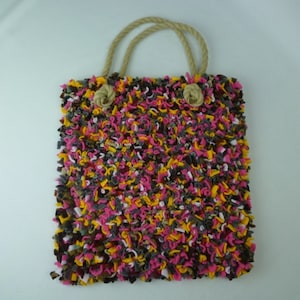 May include: A colourful tote bag made from recycled fabric scraps. The bag has a brown, pink, yellow, and white colour scheme and features a knotted rope handle.
